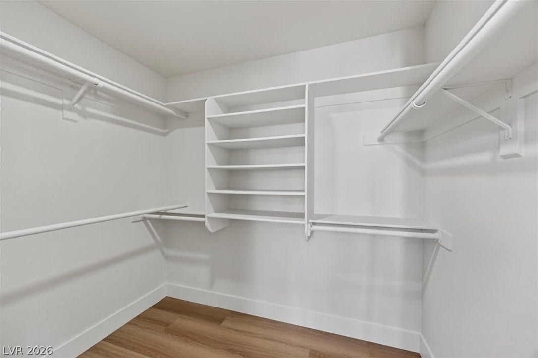 136 Villaggio Street, Henderson, NV 89074 Ample built-in shelving and hanging rods maximize storage in this walk-in closet with wood-style flooring.