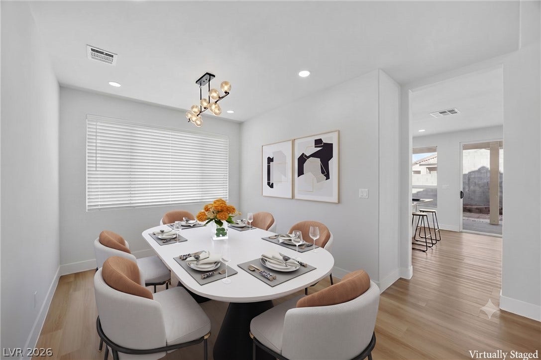 136 Villaggio Street, Henderson, NV 89074 Gleaming hardwood floors and a modern light fixture elevate this elegant dining space.