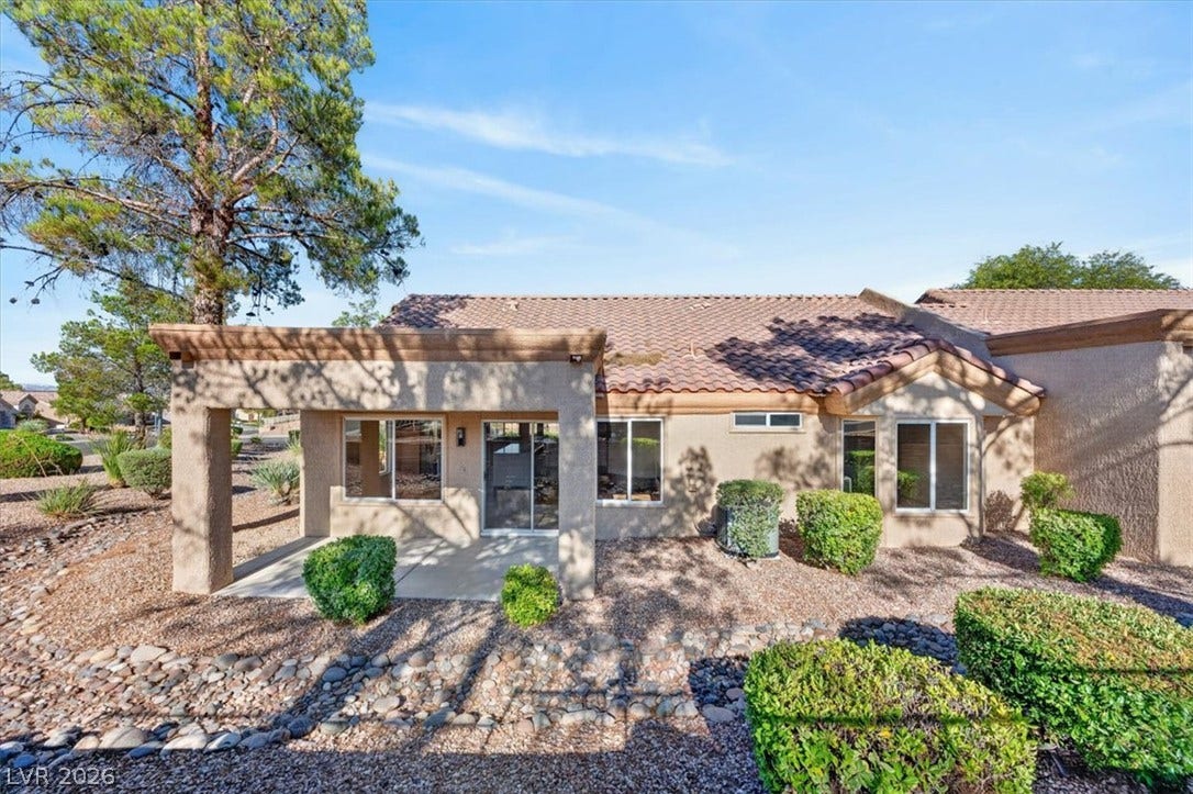A well-maintained desert landscape frames this property's rear patio and numerous windows.