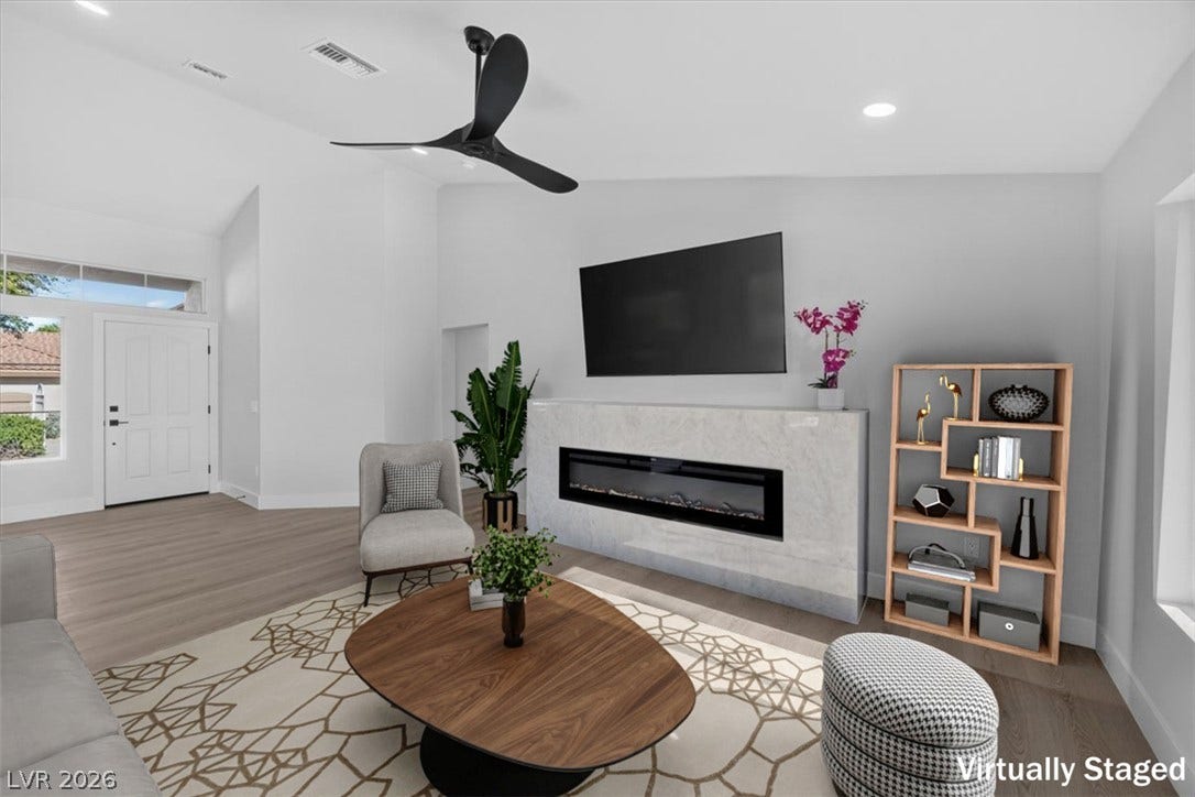 A refined living area boasts a modern fireplace and elegant flooring, creating a comfortable gathering space.