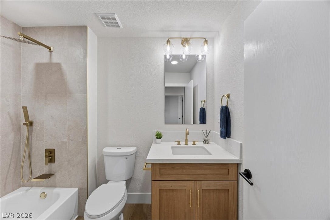A well-appointed bathroom with a sleek vanity and modern brass fixtures.