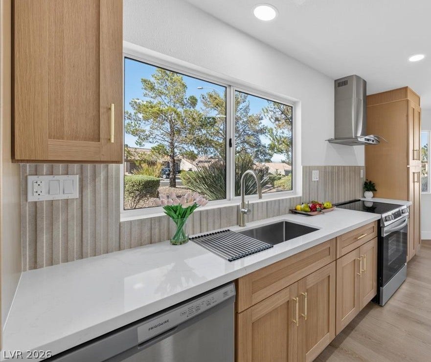 Crisp white countertops and light wood cabinetry define this luminous kitchen space.