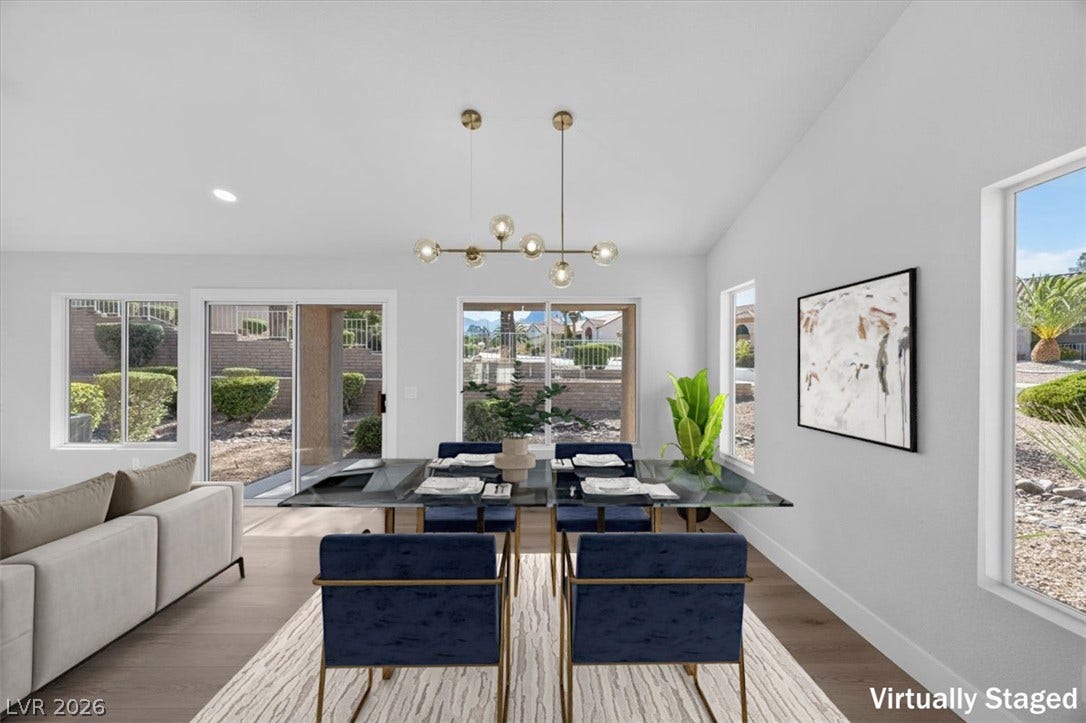 An open-concept layout unites the dining and living spaces, illuminated by natural light and contemporary fixtures.