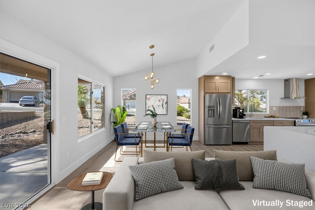 An open concept living area seamlessly connects to a modern kitchen, featuring high ceilings and sun-filled windows.