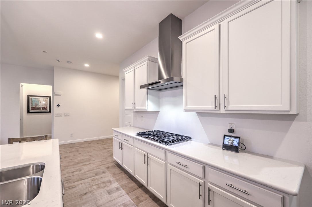 Gourmet Island Kitchen with Quartz Countertops, Breakfast Bar, Abundant Cabinetry, Walk-In Pantry, Recessed Lighting, Pendant Lighting, Touchless Faucet, and Stainless-Steel Appliances including B/I Double Oven w/ Convection Feature, Gas Cooktop, Upgraded Hood, Dishwasher, Microwave, and Refrigerator