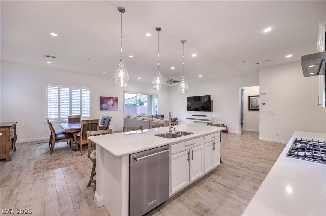 Gourmet Island Kitchen with Quartz Countertops, Breakfast Bar, Abundant Cabinetry, Walk-In Pantry, Recessed Lighting, Pendant Lighting, Touchless Faucet, and Stainless-Steel Appliances including B/I Double Oven w/ Convection Feature, Gas Cooktop, Upgraded Hood, Dishwasher, Microwave, and Refrigerator