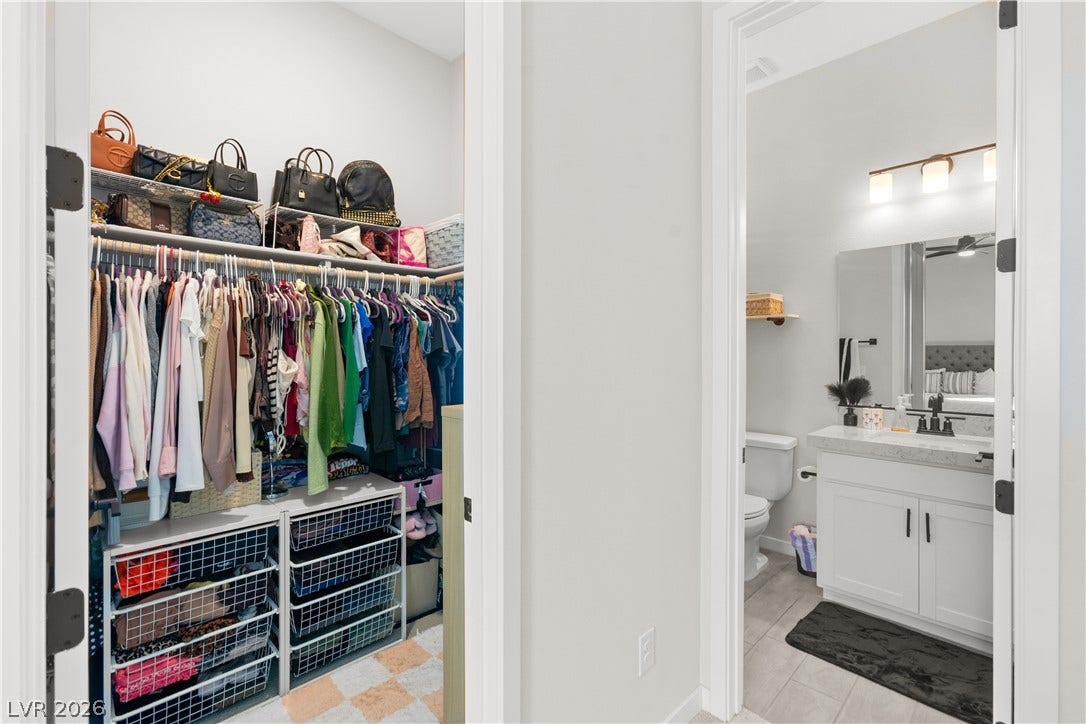 848 Purser Street, Henderson, NV 89011 A spacious walk-in closet stands adjacent to a modern bathroom finished with tile flooring.