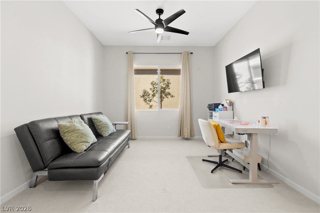 848 Purser Street, Henderson, NV 89011 Soft carpeting underfoot pairs with a wide window overlooking quiet neighborhood greenery.