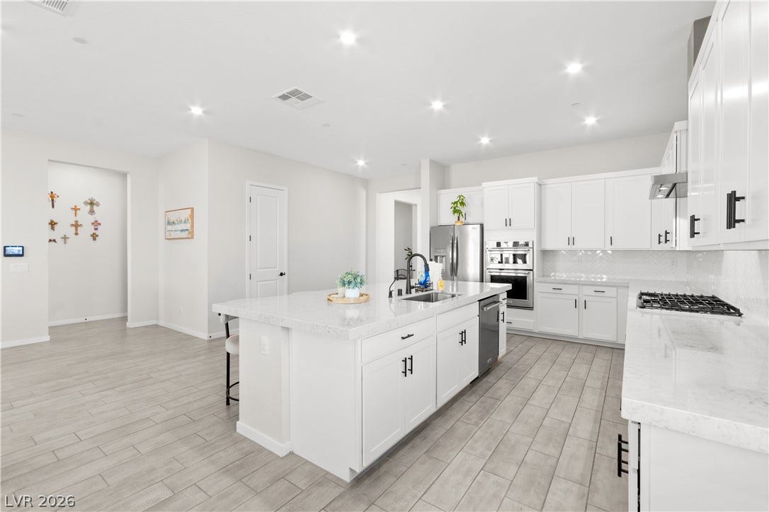 848 Purser Street, Henderson, NV 89011 Gleaming stone countertops and a spacious central island anchor this modern culinary workspace.