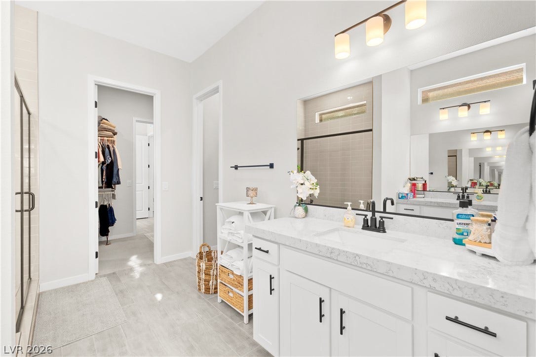 848 Purser Street, Henderson, NV 89011 Gleaming stone countertops and modern cabinetry elevate this immaculate primary bathroom.