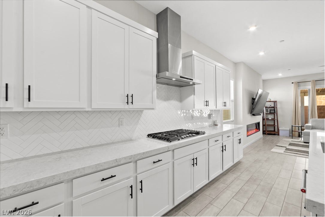 848 Purser Street, Henderson, NV 89011 Sleek cabinetry and stone countertops anchor this modern, open-concept cooking and living space.