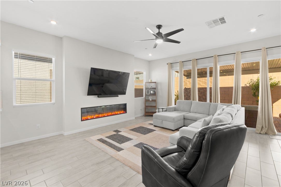848 Purser Street, Henderson, NV 89011 A modern electric fireplace anchors the spacious living area featuring wood-look tile flooring throughout.