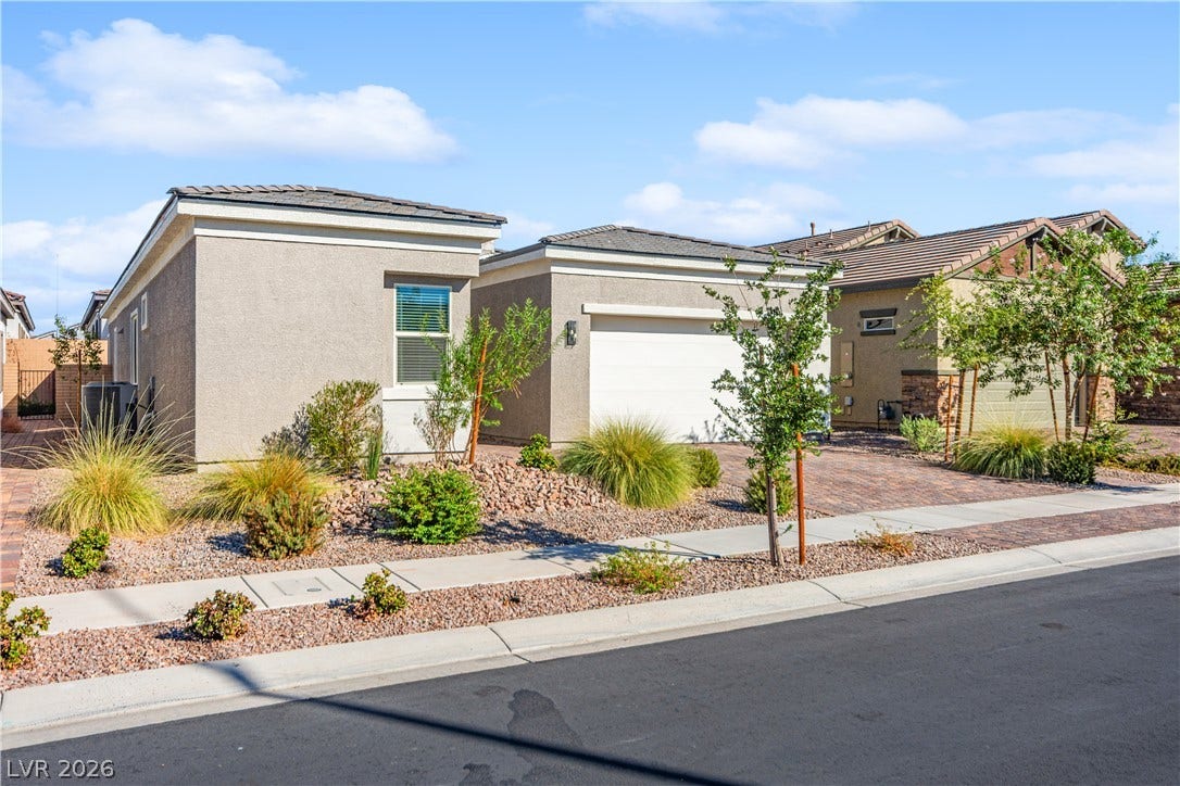 848 Purser Street, Henderson, NV 89011 Manicured desert landscaping frames the stucco exterior and paved driveway of this modern home.