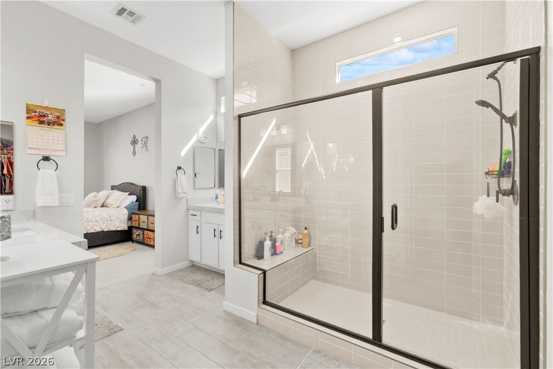 848 Purser Street, Henderson, NV 89011 Tiled walk-in shower with glass doors sits adjacent to a spacious vanity area.