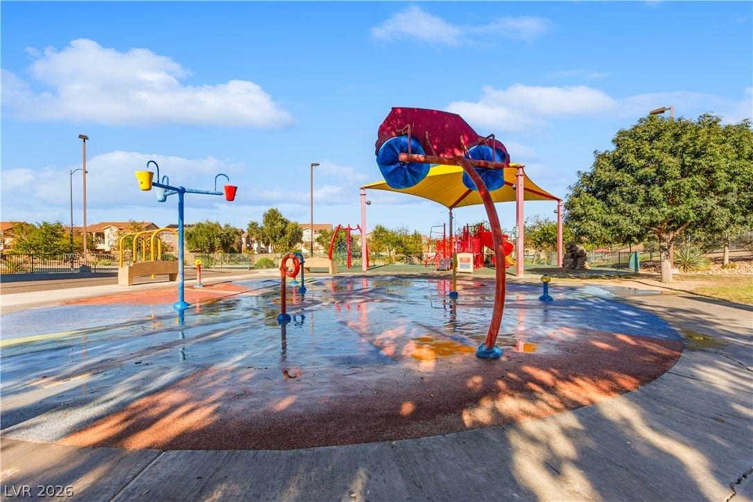 848 Purser Street, Henderson, NV 89011 A vibrant neighborhood splash pad offers outdoor recreation under a bright blue sky.