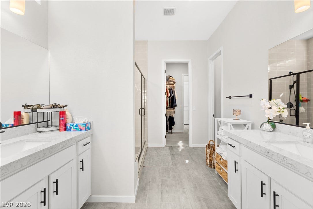 848 Purser Street, Henderson, NV 89011 Clean lines and stone counters define this modern master bath layout with walk-in closet access.