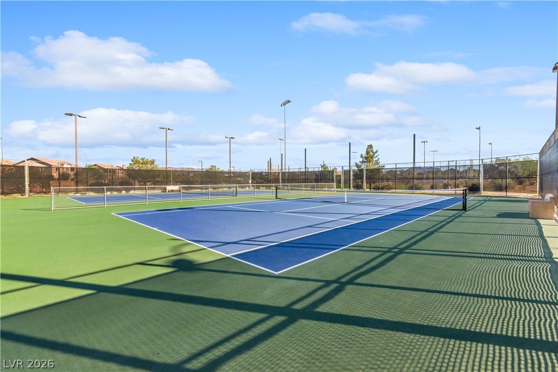 848 Purser Street, Henderson, NV 89011 Professional outdoor tennis courts sit under clear blue skies inside a fully fenced enclosure.