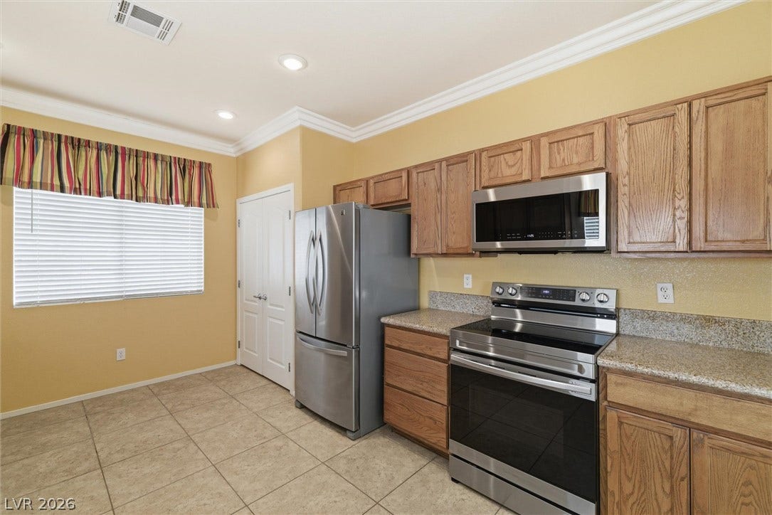 4911 S Castello Way, Pahrump, NV 89061 Crown molding and tile flooring frame this kitchen equipped with stainless steel appliances.