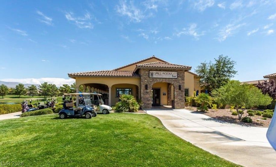 4911 S Castello Way, Pahrump, NV 89061 Stucco and stone exterior under a tiled roof sits adjacent to a lush golf course.