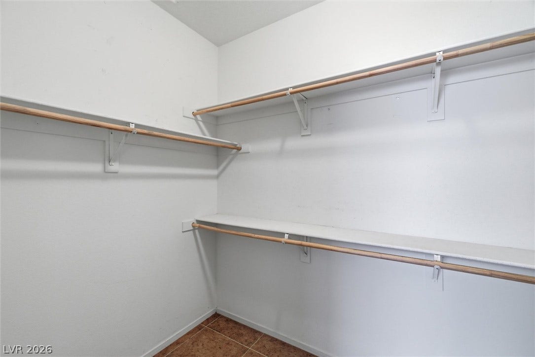 4911 S Castello Way, Pahrump, NV 89061 Tiled flooring and built-in wooden hanging rods define this functional storage space.