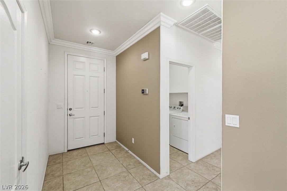 4911 S Castello Way, Pahrump, NV 89061 Tiled flooring and crown molding frame a welcoming entry leading to adjacent laundry facilities.