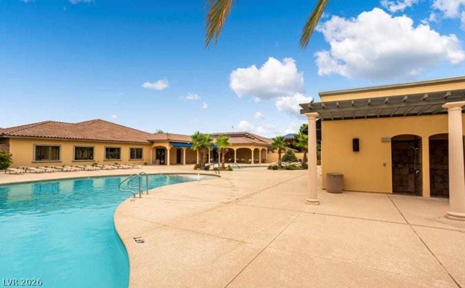 4911 S Castello Way, Pahrump, NV 89061 An expansive concrete deck surrounds the sparkling community pool under clear desert skies.