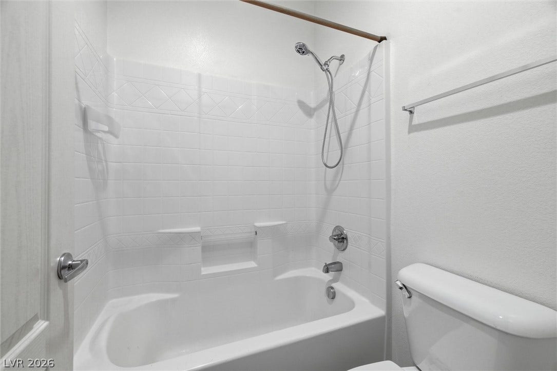 4911 S Castello Way, Pahrump, NV 89061 Clean tiling lines the shower and bathtub combination in this classic bathroom.