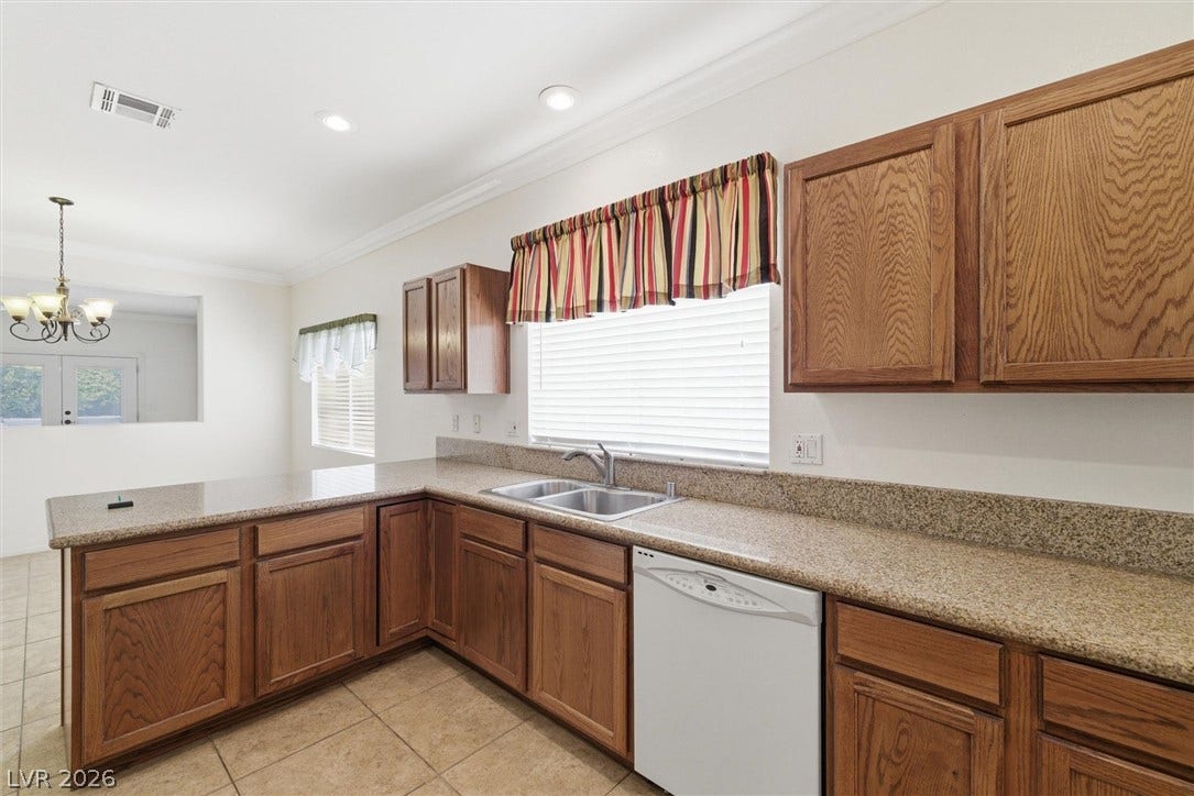 4911 S Castello Way, Pahrump, NV 89061 Rich wood cabinetry pairs beautifully with expansive stone countertops in this inviting kitchen.