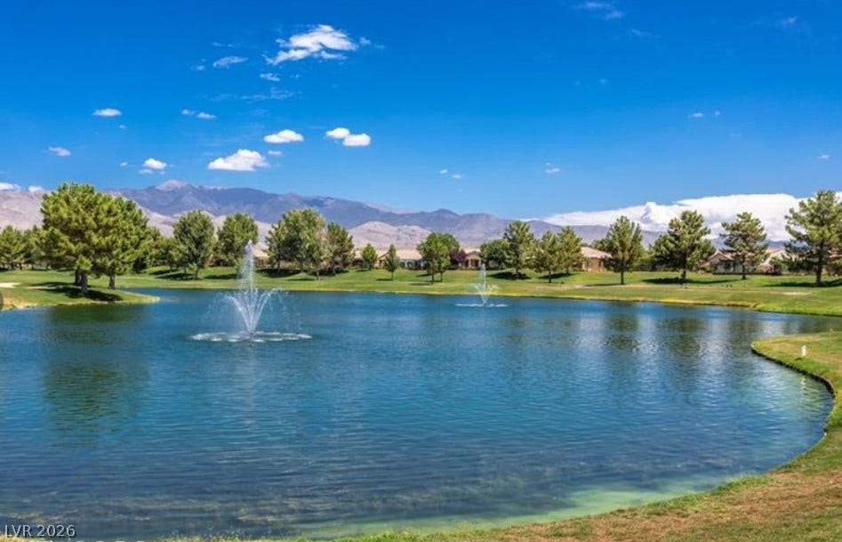 4911 S Castello Way, Pahrump, NV 89061 Serene pond waters reflect clear blue skies framed by majestic mountain backdrops.