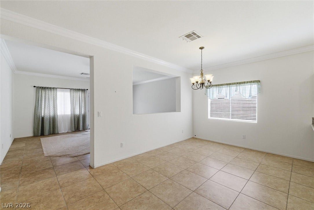 4911 S Castello Way, Pahrump, NV 89061 Tiled flooring and crown molding accent this open dining area illuminated by a classic chandelier.