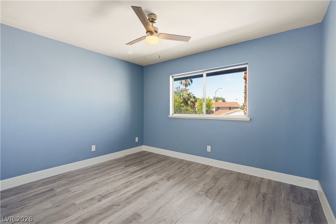 1707 Mapleton Lane, Las Vegas, NV 89119 Gleaming wood-inspired floors and a wide window define this versatile secondary bedroom space.