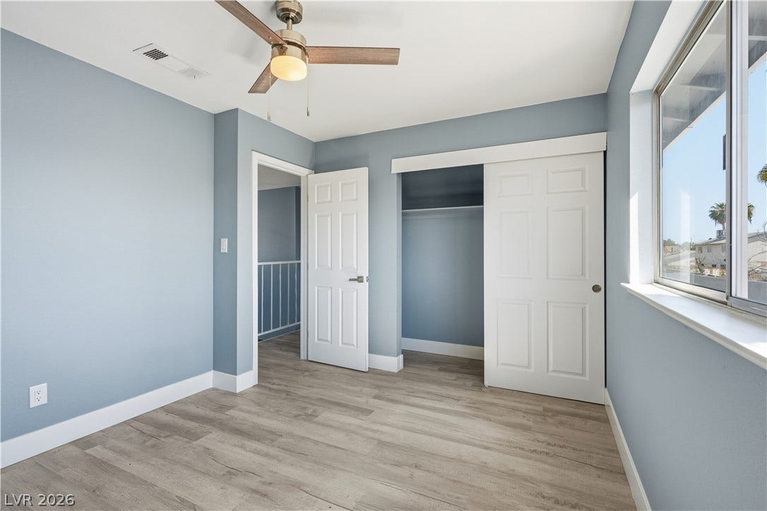 1707 Mapleton Lane, Las Vegas, NV 89119 Laminate flooring and a functional closet anchor this bright secondary bedroom.