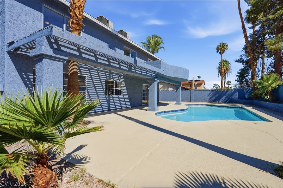 1707 Mapleton Lane, Las Vegas, NV 89119 A sparkling swimming pool highlights this backyard oasis framed by stucco architecture and towering palms.