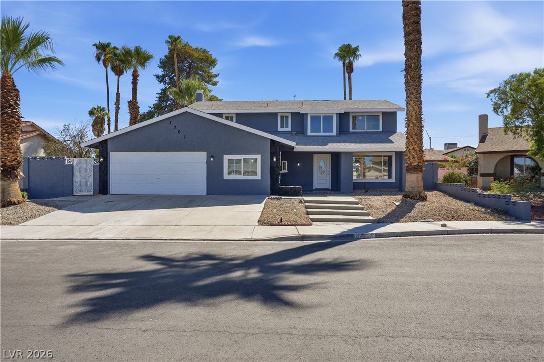 1707 Mapleton Lane, Las Vegas, NV 89119 Palm trees frame a striking two-story exterior featuring a spacious driveway and attached garage.