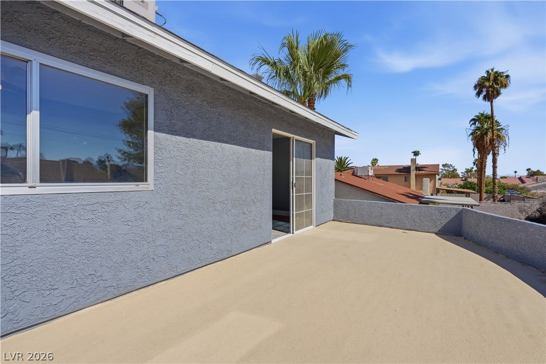 1707 Mapleton Lane, Las Vegas, NV 89119 Sliding glass doors open onto a spacious rooftop terrace set against a clear blue sky.