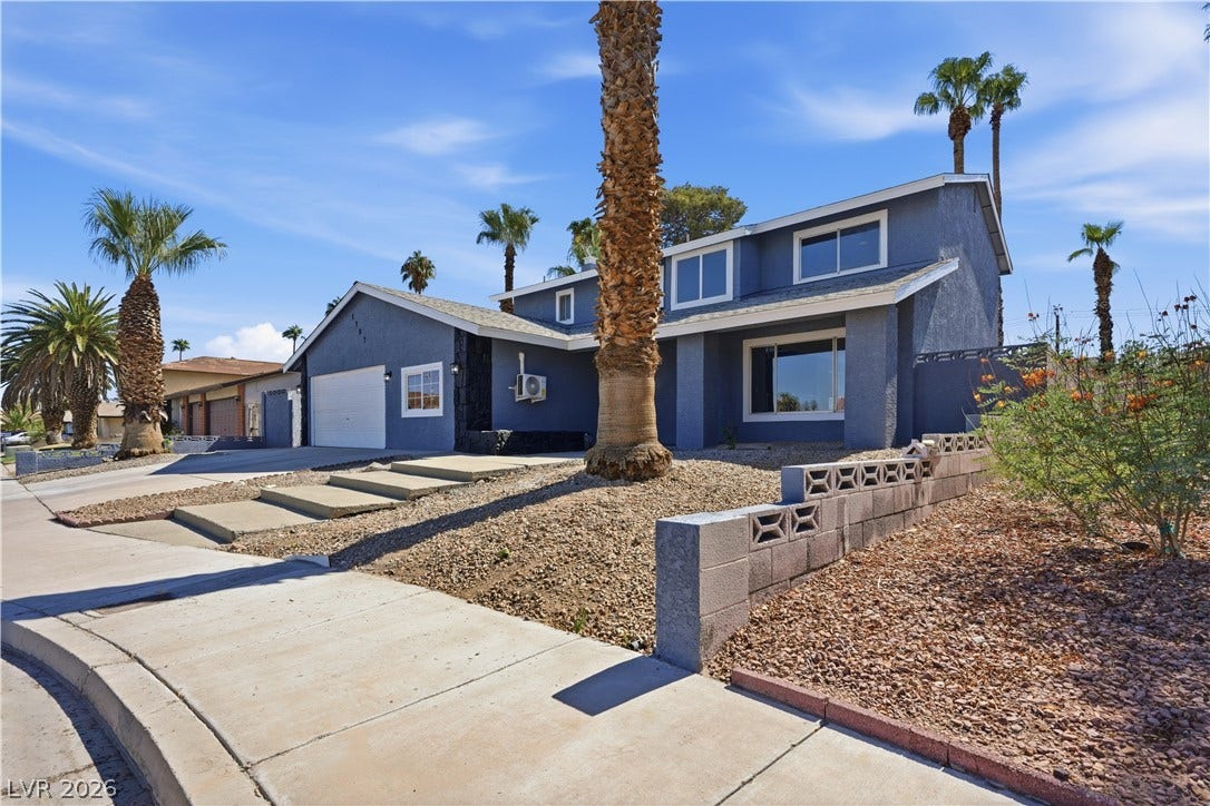1707 Mapleton Lane, Las Vegas, NV 89119 Desert landscaping and towering palms frame a two-story exterior featuring a double garage.
