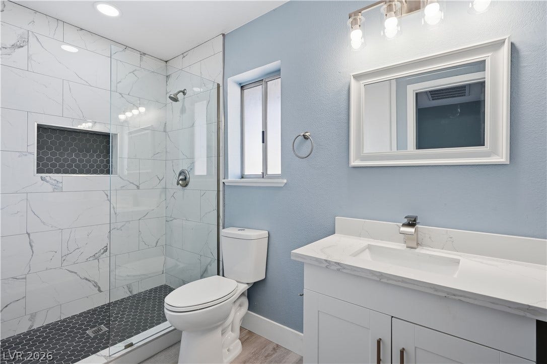 1707 Mapleton Lane, Las Vegas, NV 89119 Elegant stone countertops and a modern walk-in tile shower define this beautifully updated space.