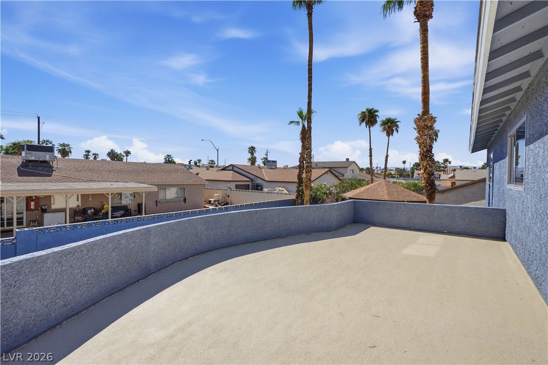 1707 Mapleton Lane, Las Vegas, NV 89119 An elevated outdoor balcony looks out over neighboring rooftops and tall palm trees.