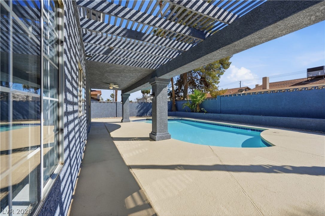 1707 Mapleton Lane, Las Vegas, NV 89119 A sparkling swimming pool rests alongside a shaded concrete patio covered by a classic pergola.