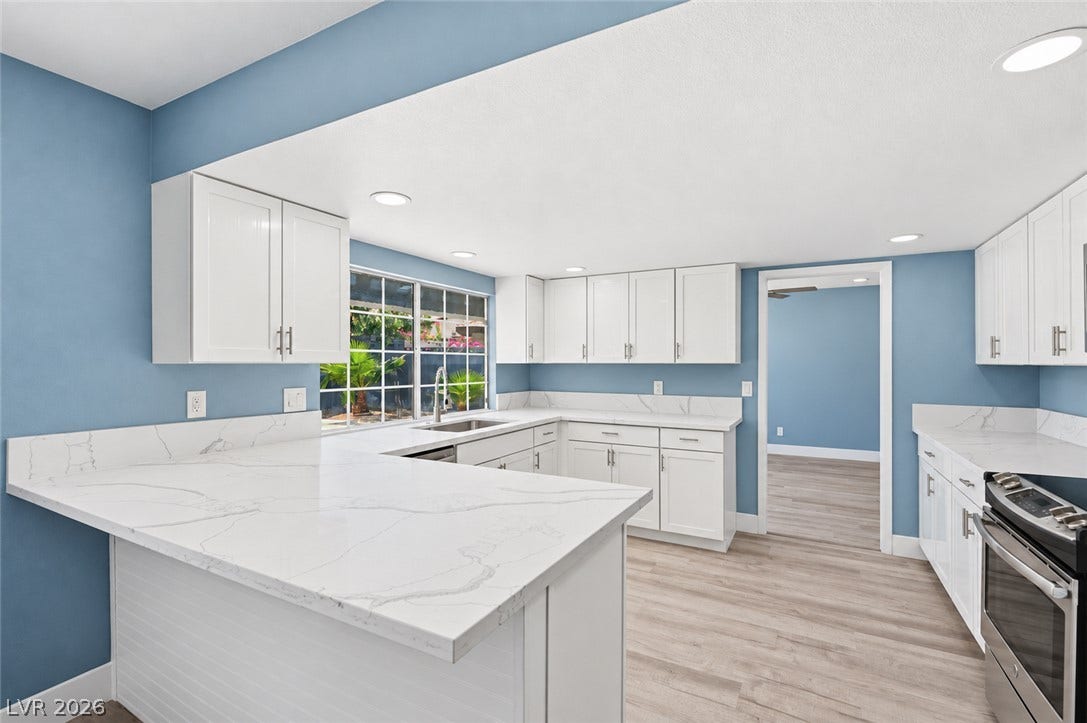 1707 Mapleton Lane, Las Vegas, NV 89119 Polished stone countertops pair beautifully with crisp shaker cabinets and wood-inspired flooring.
