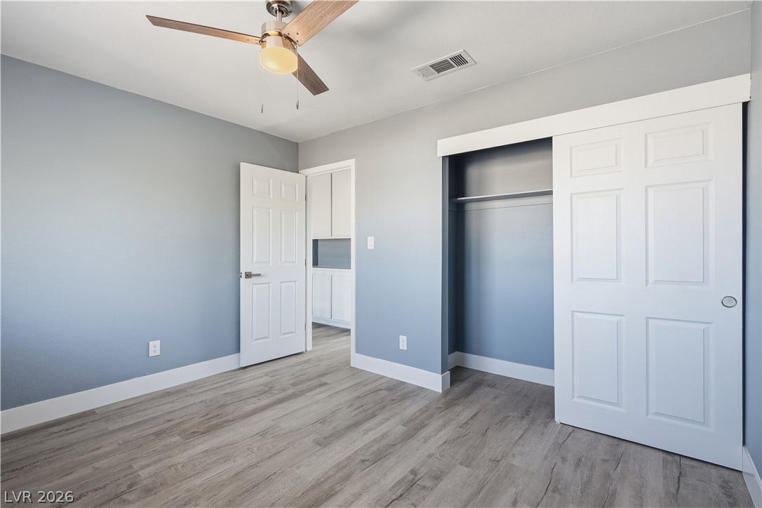 1707 Mapleton Lane, Las Vegas, NV 89119 Smooth wood-look flooring and a built-in closet anchor this versatile secondary bedroom space.