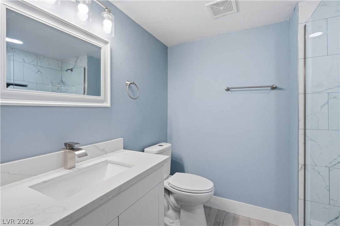 1707 Mapleton Lane, Las Vegas, NV 89119 A modern vanity with stone counters complements the adjacent tiled shower enclosure.