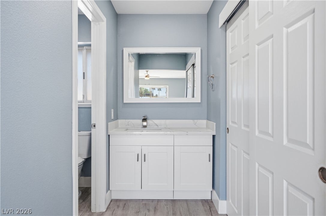 1707 Mapleton Lane, Las Vegas, NV 89119 Modern stone counters and classic wood flooring define this elegant vanity area.