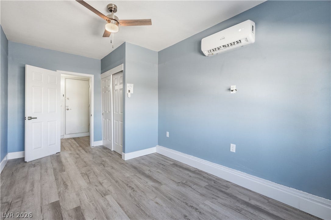 1707 Mapleton Lane, Las Vegas, NV 89119 Smooth wood-look flooring and crisp white trim accent this modern bedroom space.
