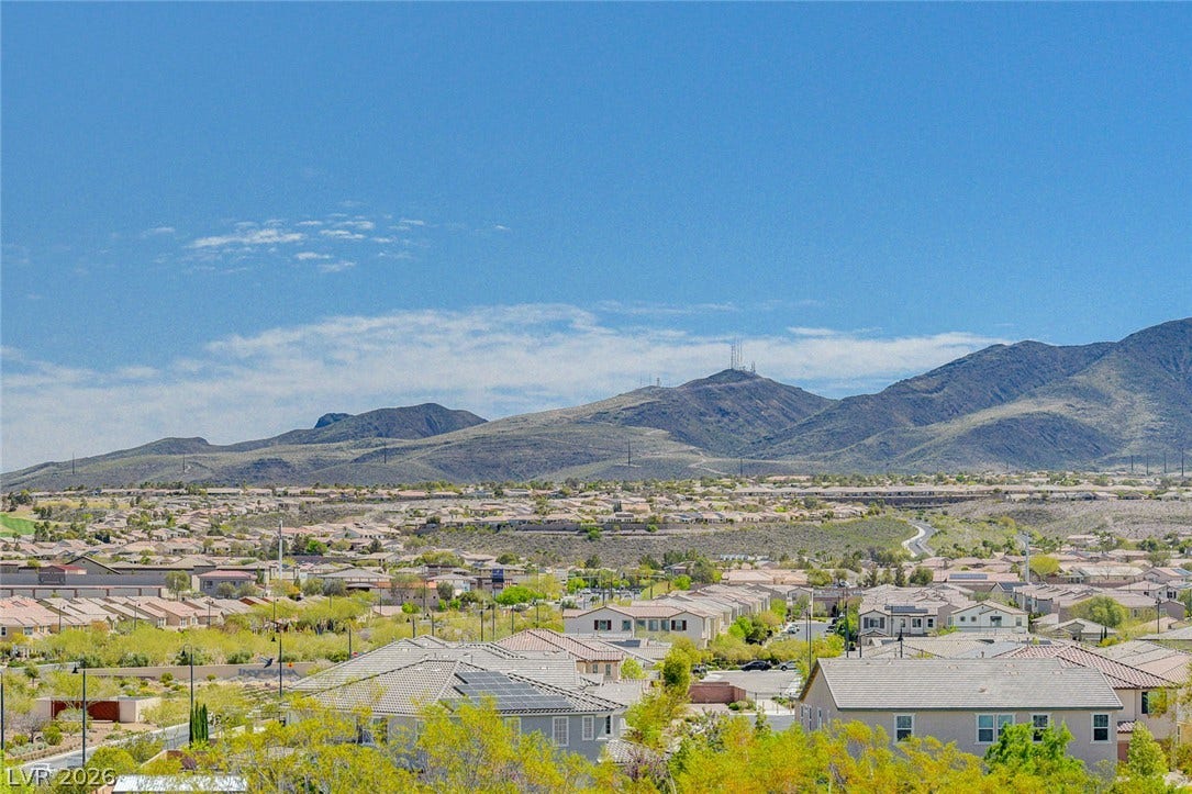 A sprawling neighborhood nestled against the majestic mountain backdrop offers scenic views