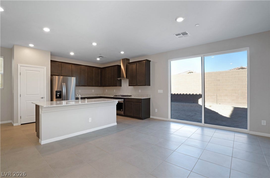 A well-appointed kitchen and living space opens to an outdoor area through expansive sliding glass doors