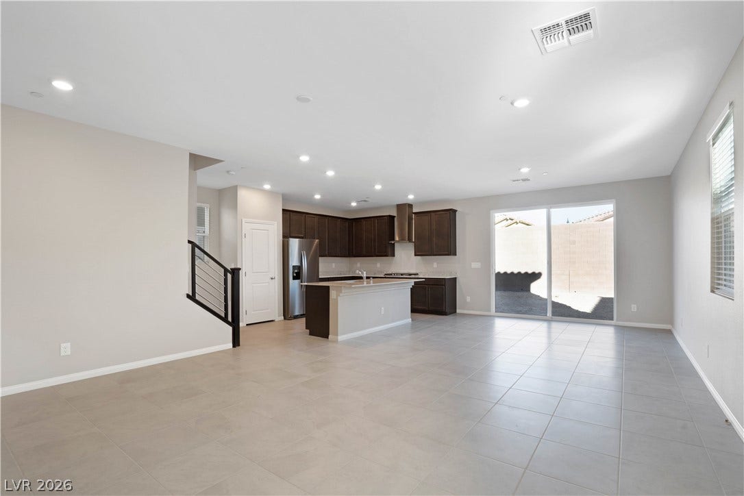 An open-concept living area features a modern kitchen and convenient outdoor access
