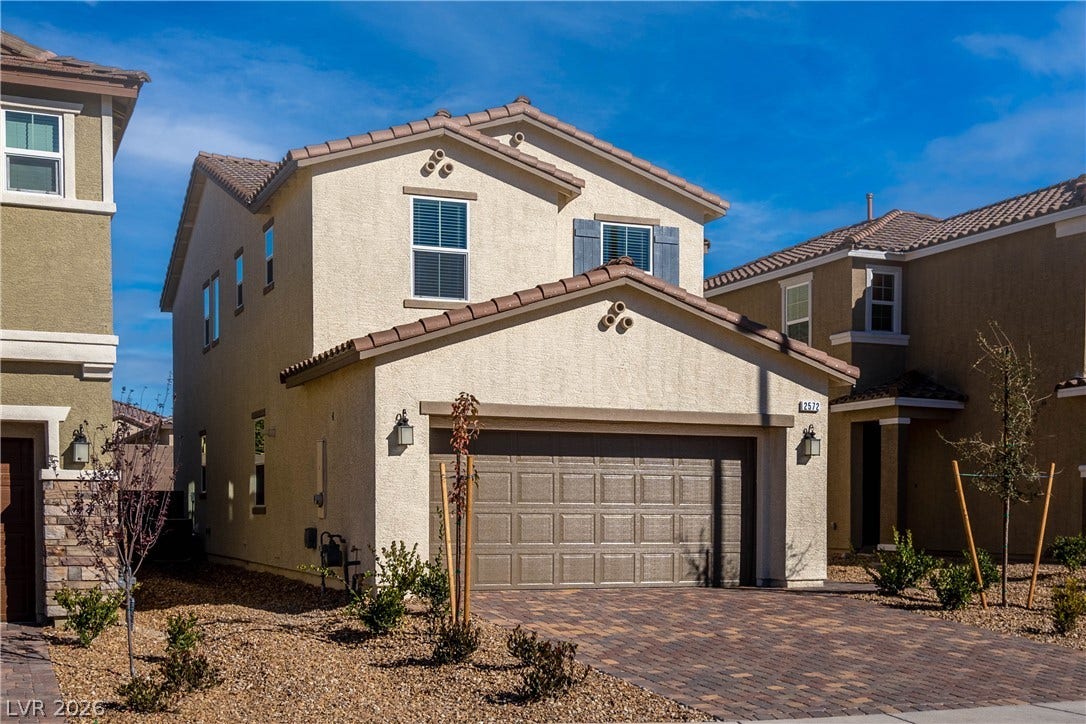 A well-maintained stucco facade with a patterned driveway welcomes you home