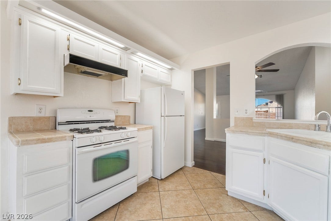 768 Panhandle Drive, Henderson, NV 89014 Crisp white cabinetry paired with durable tile flooring defines this efficient kitchen layout.