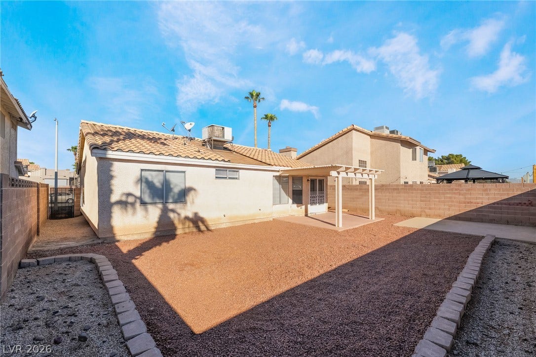 768 Panhandle Drive, Henderson, NV 89014 A low-maintenance gravel yard accompanies a covered patio beneath a tiled roof structure.